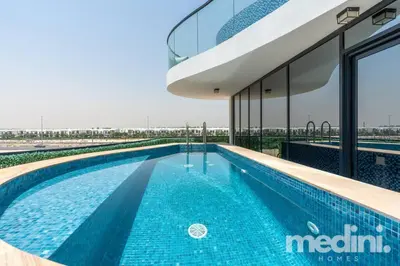 a swimming pool in front of a building at 2 bhk with Private Pool - Samana Golf Avenue - Dubai in Dubai