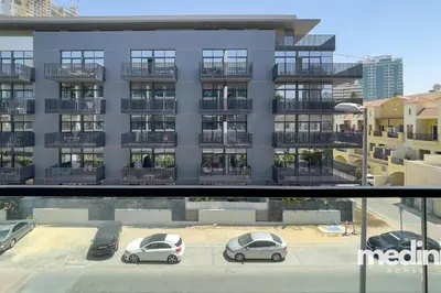 a building with cars parked in a parking lot at Oxford Boulevard - Studio - JVC Dubai in Dubai
