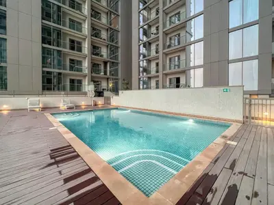 a swimming pool in a building with tall buildings at The Smarft Concierge - Sobha Creek Vista in Dubai