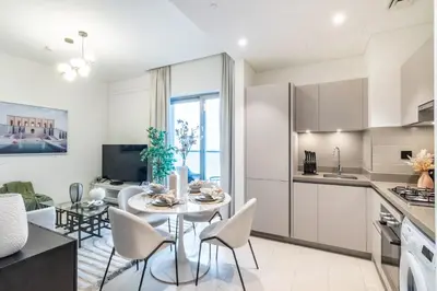a kitchen and living room with a table and chairs at The Smarft Concierge - Sobha Creek Vista in Dubai