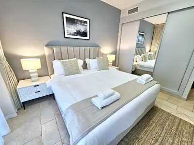 a bedroom with a large bed with towels on it at Spacious 1-BR close to Barasti Beach and Marina Walk in Dubai