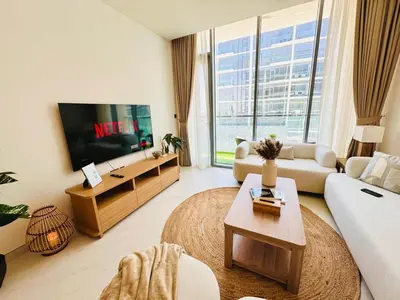 a living room with a couch and a tv at Fully Furnished 1br W Relaxing Lagoon View in Dubai