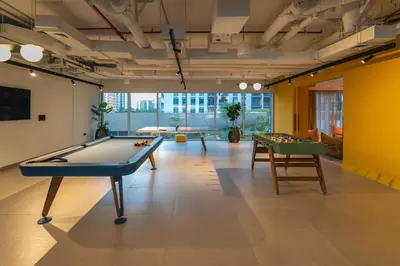 a room with a pool table and two tables at Oraya - Stylish 2BR in Socio Tower 2 With Pool View in Dubai
