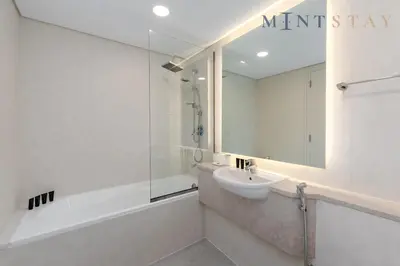 a bathroom with a sink and a tub and a mirror at Sky Gardens, Park Avenue, DIFC - Mint Stay in Dubai