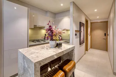 a kitchen with a counter with a vase of flowers on it at Apartment 816 Sobha Waves in Dubai