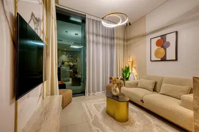 a living room with a couch and a tv at Apartment 816 Sobha Waves in Dubai