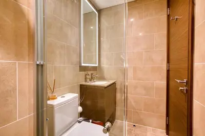 a bathroom with a toilet and a sink and a shower at Apartment 816 Sobha Waves in Dubai