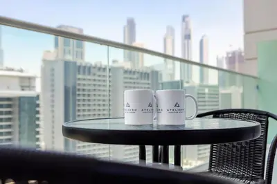 two white coffee mugs sitting on a table in front of a window at DAMAC Vera 1BR with Downtown & Burj Khalifa View in Dubai