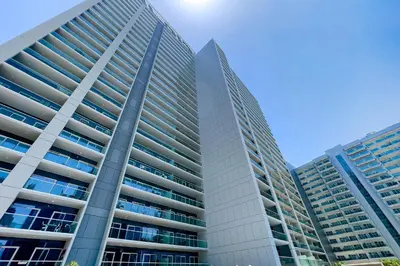 two tall buildings in front of a blue sky at DAMAC Vera 1BR with Downtown & Burj Khalifa View in Dubai