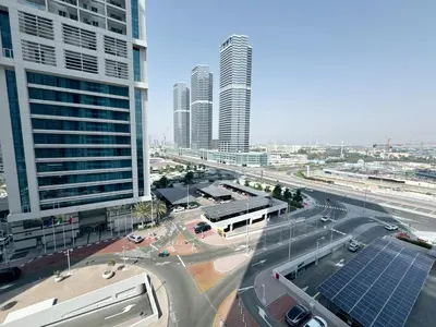a city with tall buildings and a street with cars at Cosmos Living Charming Studio With Balcony in Dubai
