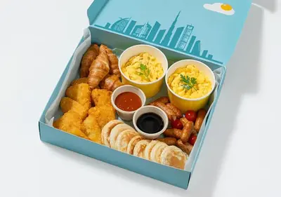 a bento box filled with different types of food at Cosmos Living Charming Studio With Balcony in Dubai