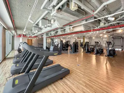 a gym with rows of treadmills and elliptical machines at Elegant - 1BR - 8 MIN Burj Khalifa & Dubai Mall in Dubai