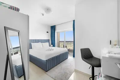 a bedroom with a bed and a mirror and a sink at 1BR Apartment minutes from Mall of the Emirates in Dubai