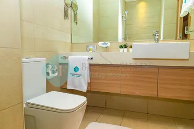 a bathroom with a toilet and a sink and a mirror at Bloomfields Stu View Azizi Riviera Meydan in Dubai