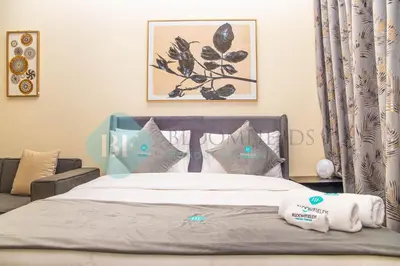 a bedroom with a bed and a couch at Bloomfields Stu View Azizi Riviera Meydan in Dubai