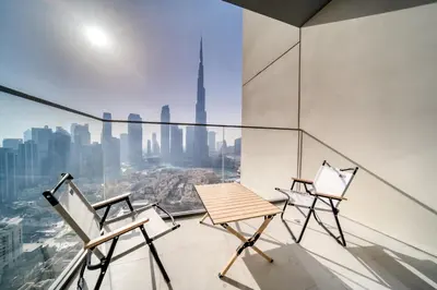 two chairs and a table on a glass balcony with a view at Burj Royale - Burj Khalifa View, Downtown Dubai in Dubai