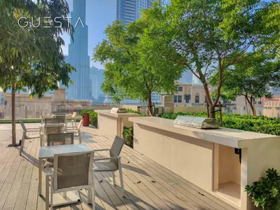 a table and chairs on a deck with a view of a city at Burj Royale - Burj Khalifa View, Downtown Dubai in Dubai