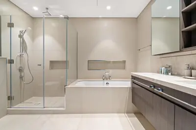 a bathroom with a shower and a tub and a sink at 3BR plus maid's room with Burj Khalifa views in Dubai