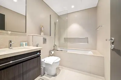 a bathroom with a toilet and a sink and a tub at 3BR plus maid's room with Burj Khalifa views in Dubai