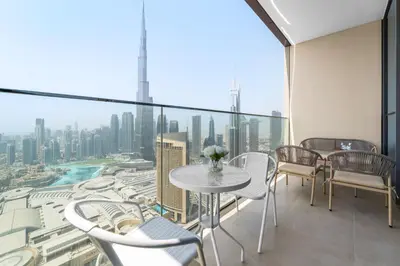 a balcony with tables and chairs and a view of the city at 3BR plus maid's room with Burj Khalifa views in Dubai