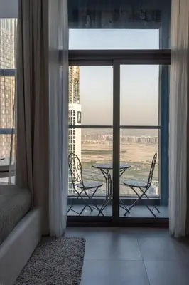a room with a balcony with a table and chairs at Waves - Comfort and Style in a 21st-Floor Studio With View in Dubai