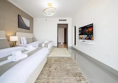 a living room with two white couches and a tv at SmartStay at Opera Grand - Stunning Burj Khalifa Views - Brand New Luxury Residences in Dubai