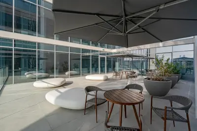 a building with tables and chairs and a large umbrella at Your Keys Holiday Homes in Dubai