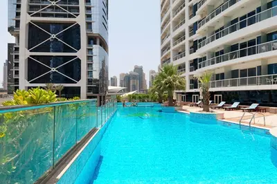 a swimming pool with blue water in a building at Stunning skyline- lake view modern cozy apartment in Dubai