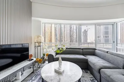 a living room with a couch and a table at Stunning skyline- lake view modern cozy apartment in Dubai