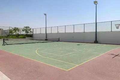 a tennis court with two nets on it at Tranquil Studio with Golf View in Dubai