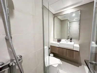 a bathroom with a toilet and a sink and a mirror at EasyGo - Unbeatable Deals on Urban Rentals in Riviera 16 in Dubai