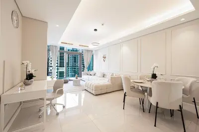 a white living room with a table and a couch at Boulevard 2 Bedroom Family Apartment with BURJ KHALIFA view and INFINITY POOL in 64th Floor Dubai Downtown in Dubai