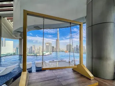 a swing in a room with a view of the city at Boulevard 2 Bedroom Family Apartment with BURJ KHALIFA view and INFINITY POOL in 64th Floor Dubai Downtown in Dubai