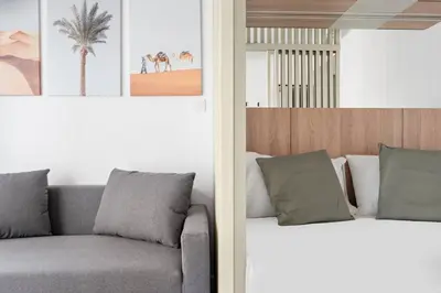 a bedroom with a couch and a palm tree at New Design Studio next to Burj Khalifa, Mall & Dubai Fountain in Dubai