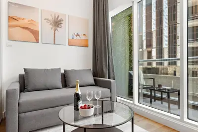 a living room with a couch and a table with wine glasses at Renovated Studio next to Dubai Mall & Burj Khalifa in Dubai