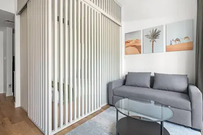 a living room with a couch and a glass table at Renovated Studio next to Dubai Mall & Burj Khalifa in Dubai