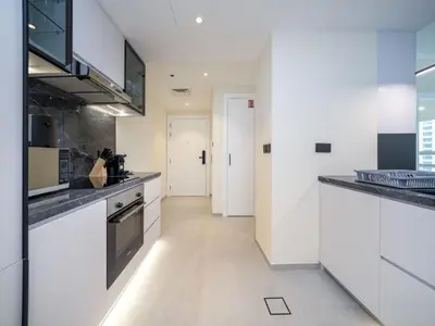 a kitchen with white appliances and a hallway at Stylish Upgraded 1 Bedroom Marina Escape in Dubai