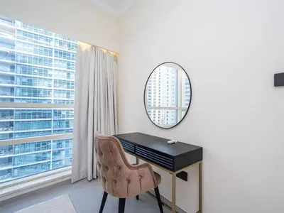 a desk with a mirror and a chair in a room at Stylish Upgraded 1 Bedroom Marina Escape in Dubai