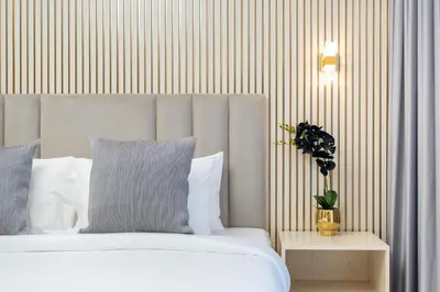 a bedroom with a white bed and a striped wall at Globalstay Creek Horizon Modern Apartments in Dubai