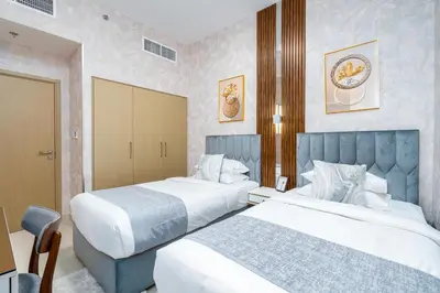 a hotel room with two beds and a chair at Globalstay Creek Horizon Modern Apartments in Dubai