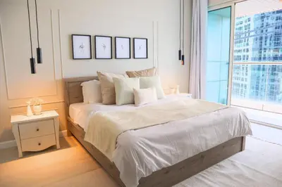 a bedroom with a large bed and a large window at Spacious 1BR, Pool, Gym, Near Dining & Shops in Dubai