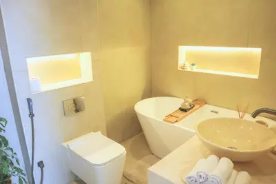 a bathroom with a tub and a sink and a toilet at Spacious 1BR, Pool, Gym, Near Dining & Shops in Dubai