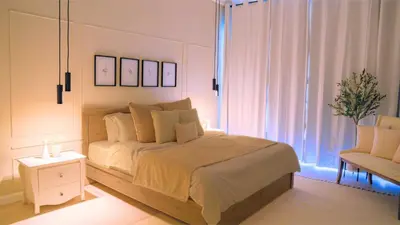 a bedroom with a large bed and a chair at Spacious 1BR, Pool, Gym, Near Dining & Shops in Dubai