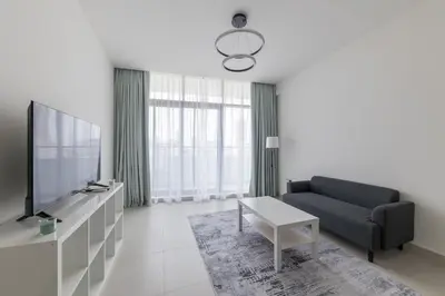 a living room with a couch and a tv at Splendid 1BR in Living Garden in Dubai
