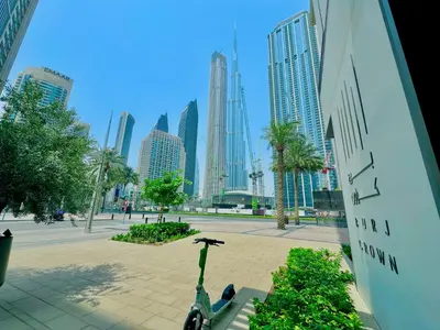 a scooter parked in a park with tall buildings at New Elegance at Burj Crown downtown Balcony & View in Dubai