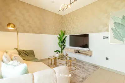 a living room with a couch and a tv at Manzil - 1BR Apartment in Sobha Hartland with City Views in Dubai