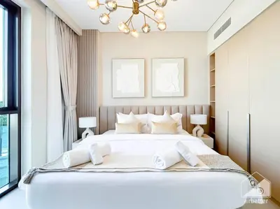 a bedroom with a large white bed with a chandelier at Amazing stay at Dubai creek with Balcony & View in Dubai