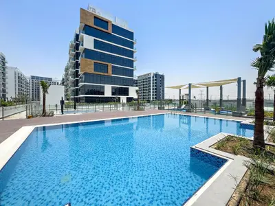 a large swimming pool in front of a tall building at Silkhaus Luxurious Studio in High End Neighborhood in Dubai