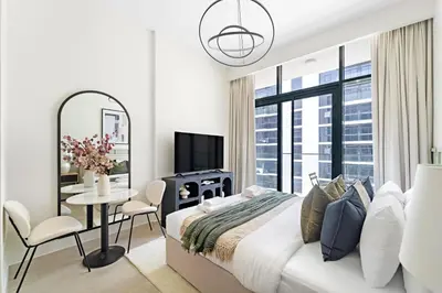 a white bedroom with a bed and a mirror at Silkhaus Luxurious Studio in High End Neighborhood in Dubai