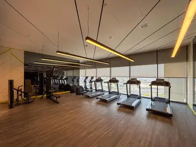 a gym with a row of treadmills in a building at Frank Porter - Aykon City Tower in Dubai